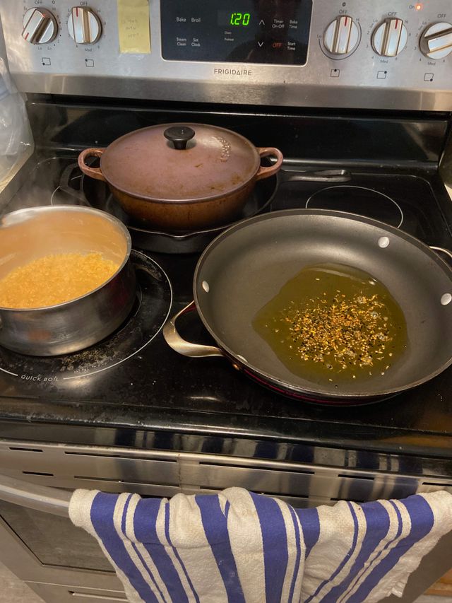 Red lentils cooking and pan with oil and cumin in it